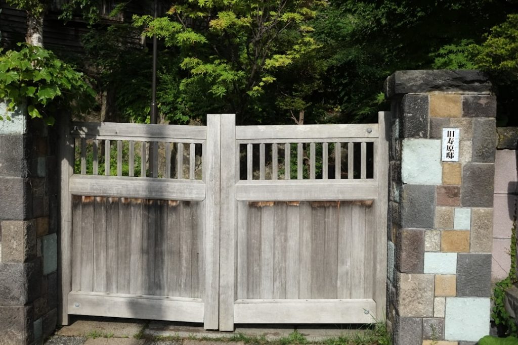 a-wooden-gate-with-a-stone-wall-behind-it-etl1tzi85y8 a-wooden-gate-with-a-stone-wall-behind-it-etl1tzi85y8